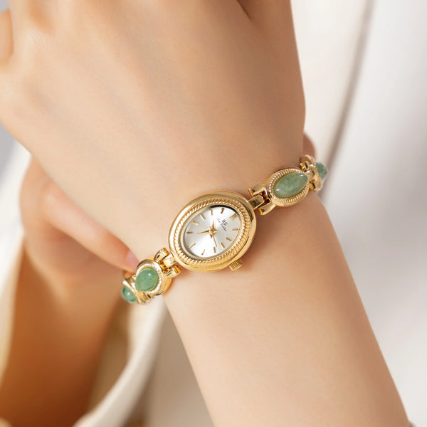 Reloj elegante con piedras verdes y esfera clásica